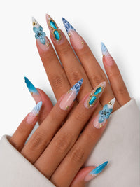 Manucure Cherry Rouge Azure Shell stiletto longue avec fleurs bleues, coquillages 3D, perles et détails dorés nacrés