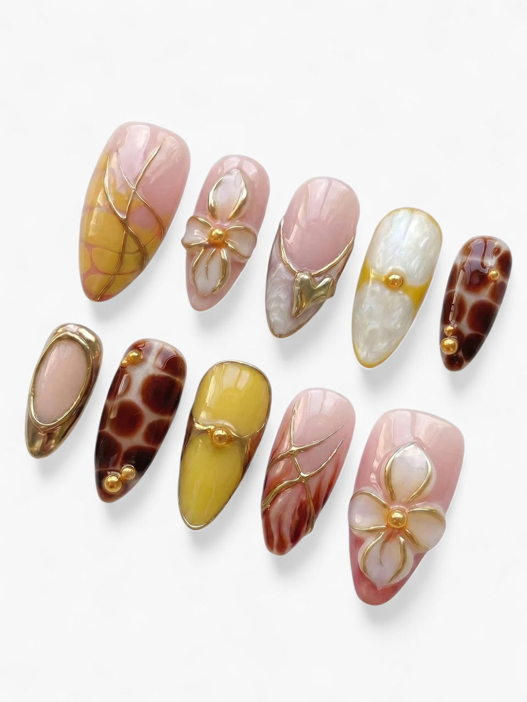 Set de 10 faux ongles Cherry Rouge en forme amande avec motifs floraux, détails dorés et finitions nude et marron