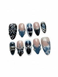 Set de 10 faux ongles Cherry Rouge Dewdrop Romance Blue en forme amande avec motifs bleus, noirs, nude et dorés.