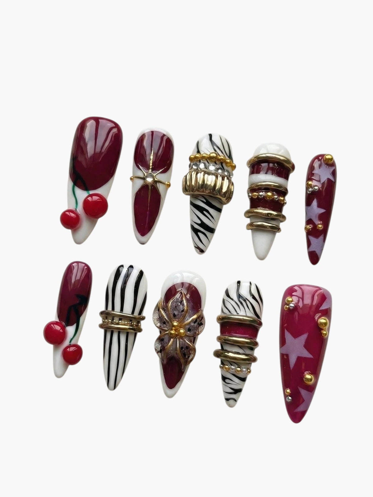 Set de faux ongles Cherry Rouge Cherry Mirage en amande avec motifs cerises, rayures zébrées, étoiles et bijoux dorés