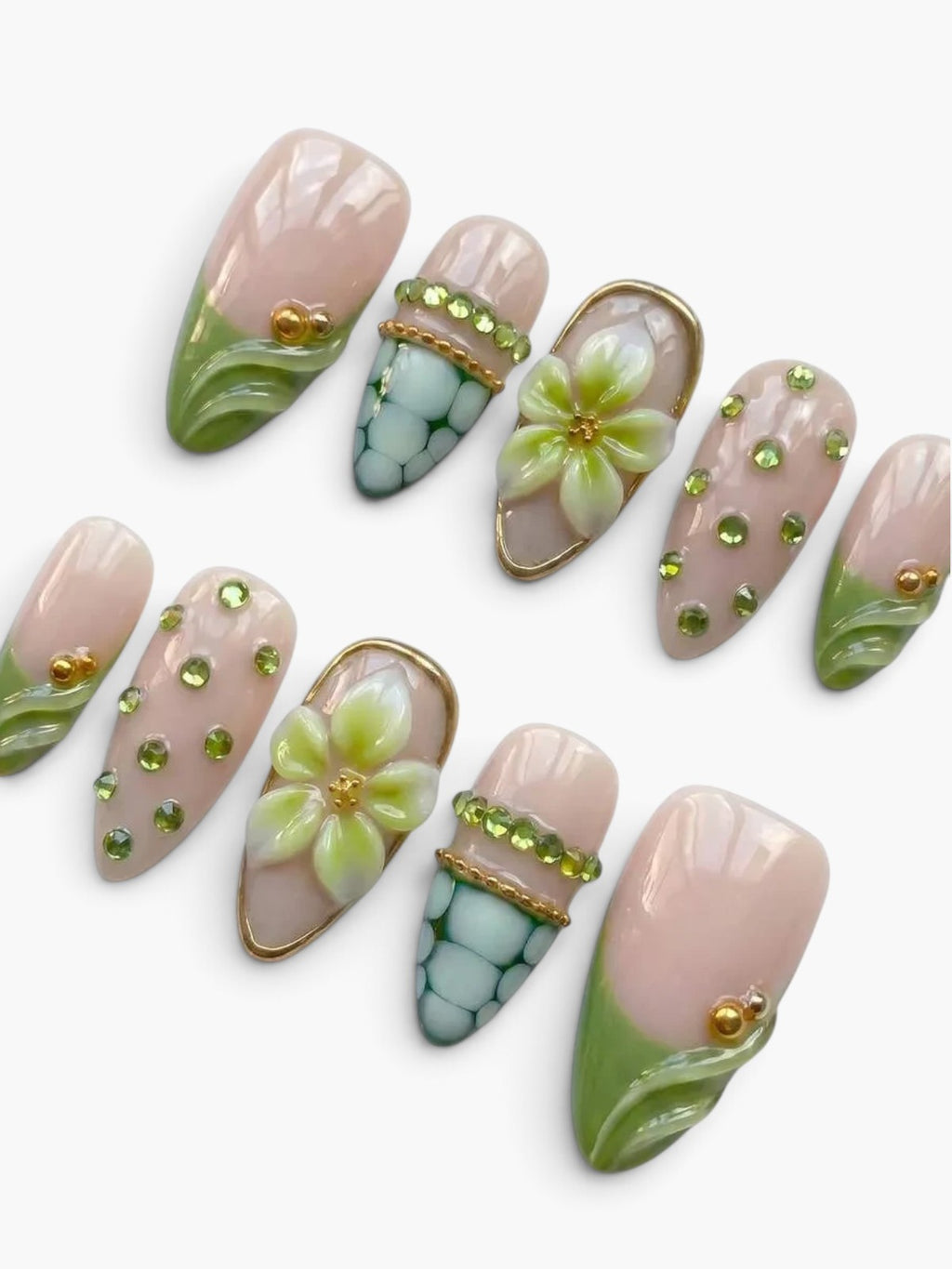 Faux ongles Cherry Rouge en amande nude rosé avec fleurs en relief, strass verts et détails dorés, finition gel