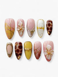 Set de 10 faux ongles Cherry Rouge en forme amande, décorés de motifs graphiques, fleurs en relief et détails dorés.