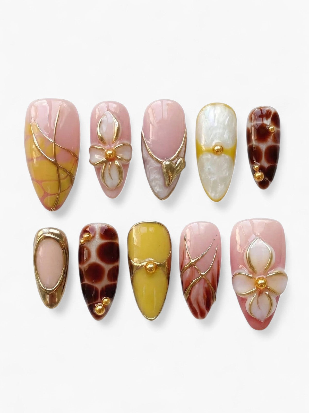Set de 10 faux ongles Cherry Rouge en forme amande, décorés de motifs graphiques, fleurs en relief et détails dorés.