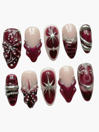 Press-on nails Cherry Rouge Dewdrop Romance Red en forme amande avec motifs floraux, étoiles argentées et relief
