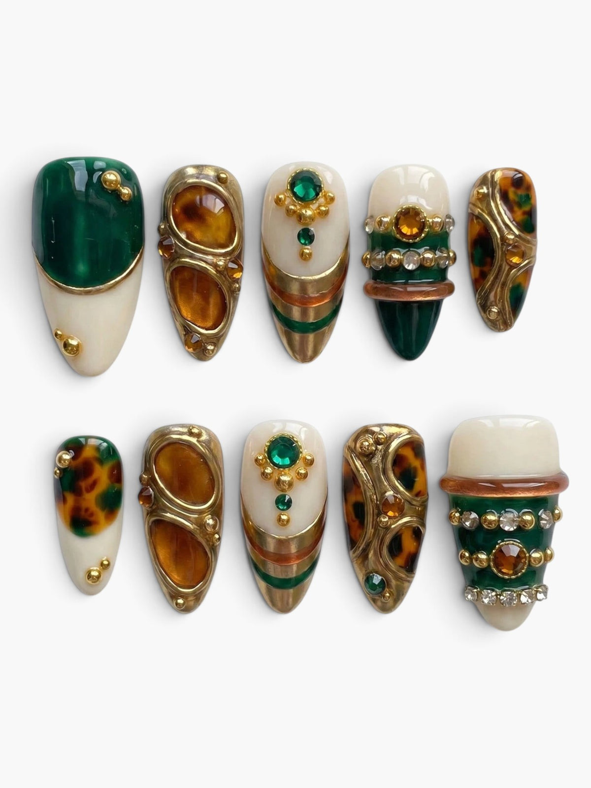 Set de 10 faux ongles Cherry Rouge en amande avec motifs écailles, strass verts et détails dorés sur fond crème