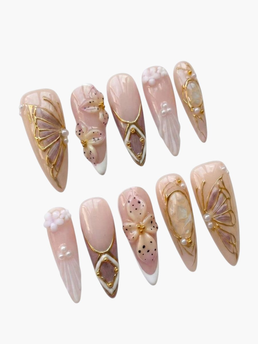 Faux ongles Cherry Rouge longs en amande avec motifs de fleurs, papillons, perles et détails dorés style Y2K