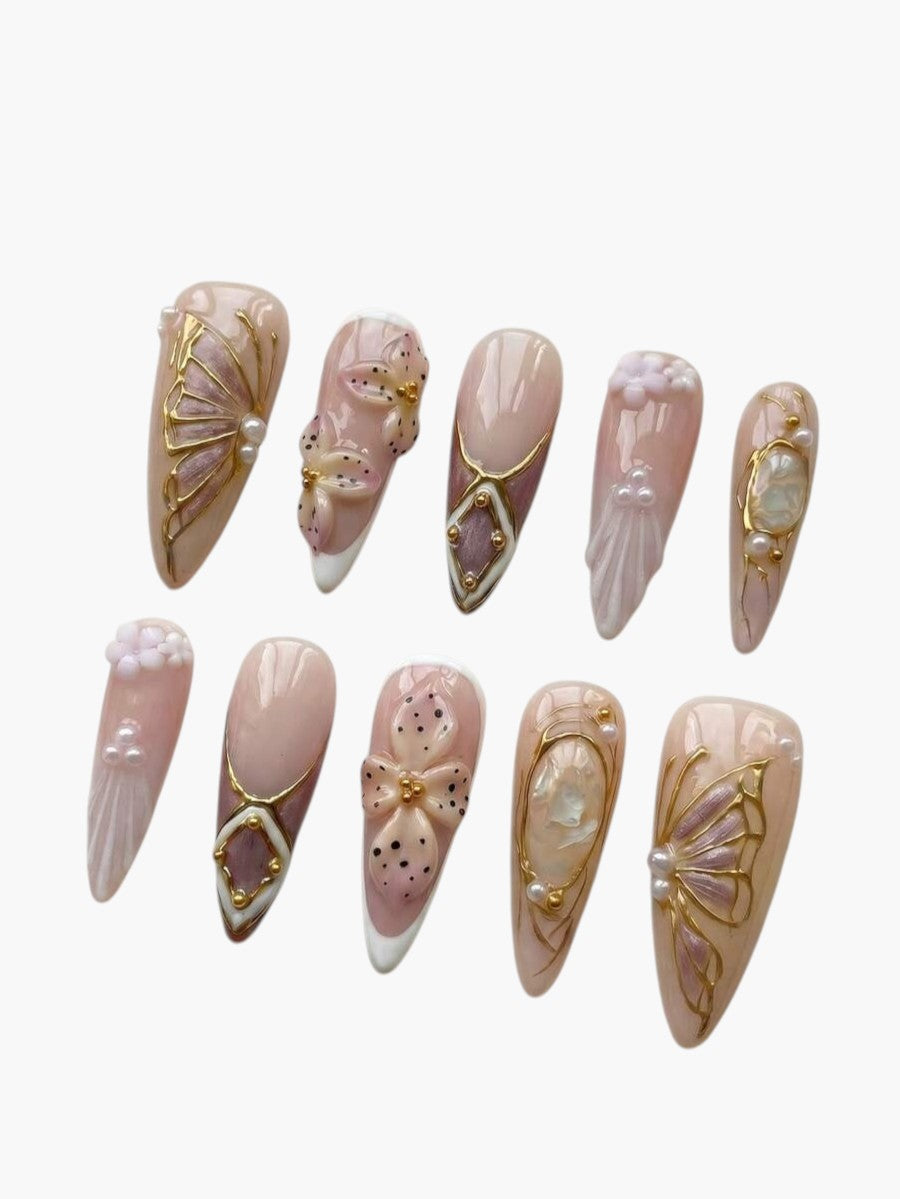 Faux ongles Cherry Rouge longs en amande avec motifs de fleurs, perles et détails dorés style Y2K sur fond beige