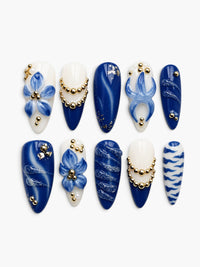 Cherry Rouge Blue Majesty faux ongles ovales longs avec fleurs 3D, perles dorées et motifs porcelaine bleu et blanc