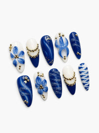 Faux ongles Cherry Rouge Blue Majesty ovales avec dégradé bleu, fleurs 3D, perles dorées et motifs porcelaine