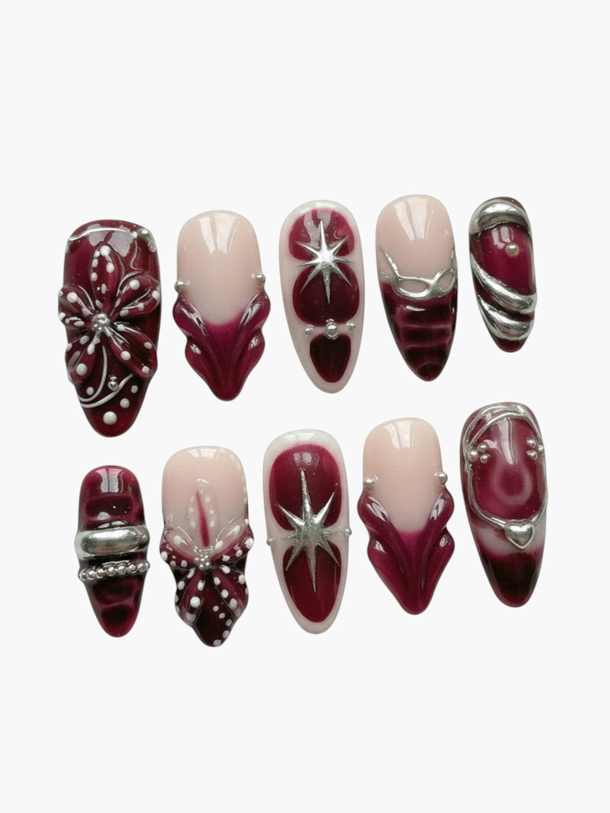 Set de 10 faux ongles Cherry Rouge en forme amande, gel bordeaux et nude avec ornements dorés et motifs étoilés.