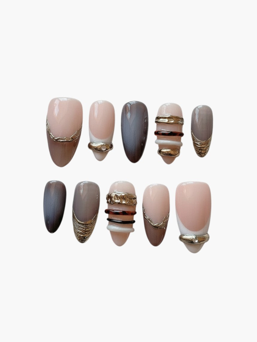 Set de 10 faux ongles Cherry Rouge Bronze Mirage en forme amande, dégradés bronze et cuivre avec détails dorés texturés.