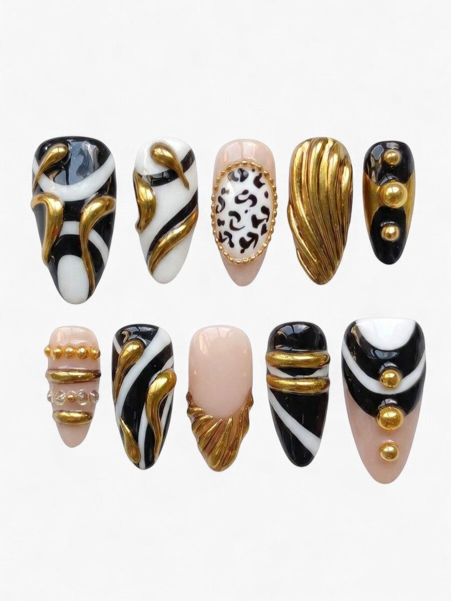 Set de 10 faux ongles Cherry Rouge Touch of Gold en forme amande, motifs noir, blanc et détails dorés 3D luxueux.