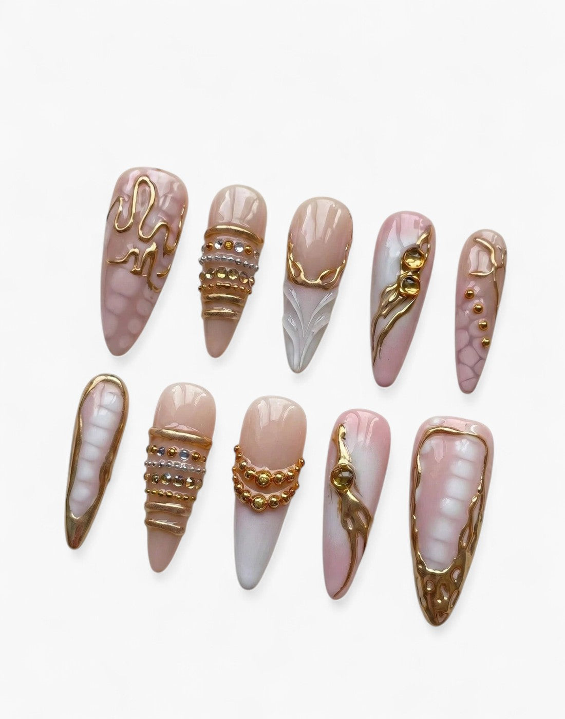 Set de 10 faux ongles Cherry Rouge en forme amande, design nude irisé et rose pâle avec reliefs dorés et brillants.