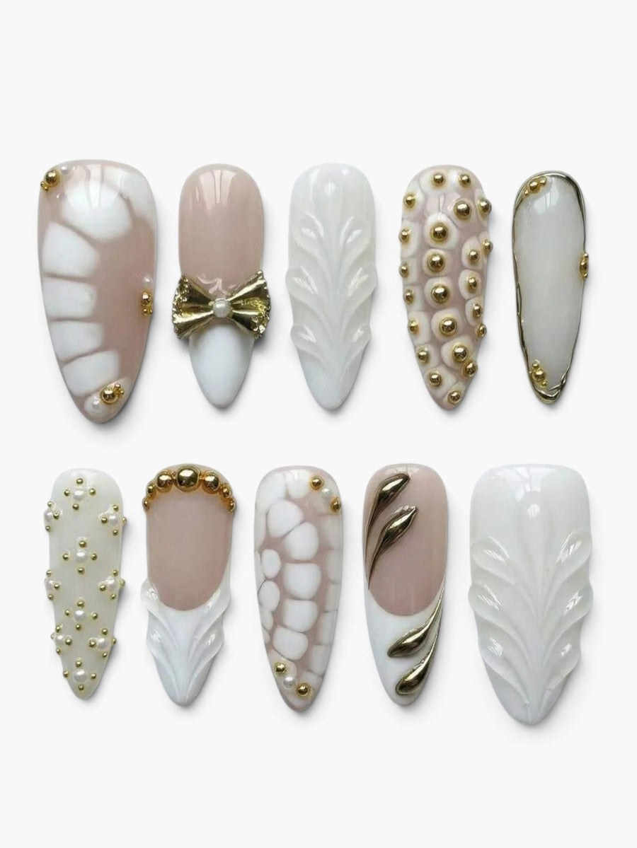 Set de 10 faux ongles Cherry Rouge Silken Kiss Nude en forme amande avec motifs serpent, perles dorées et nœud élégant.