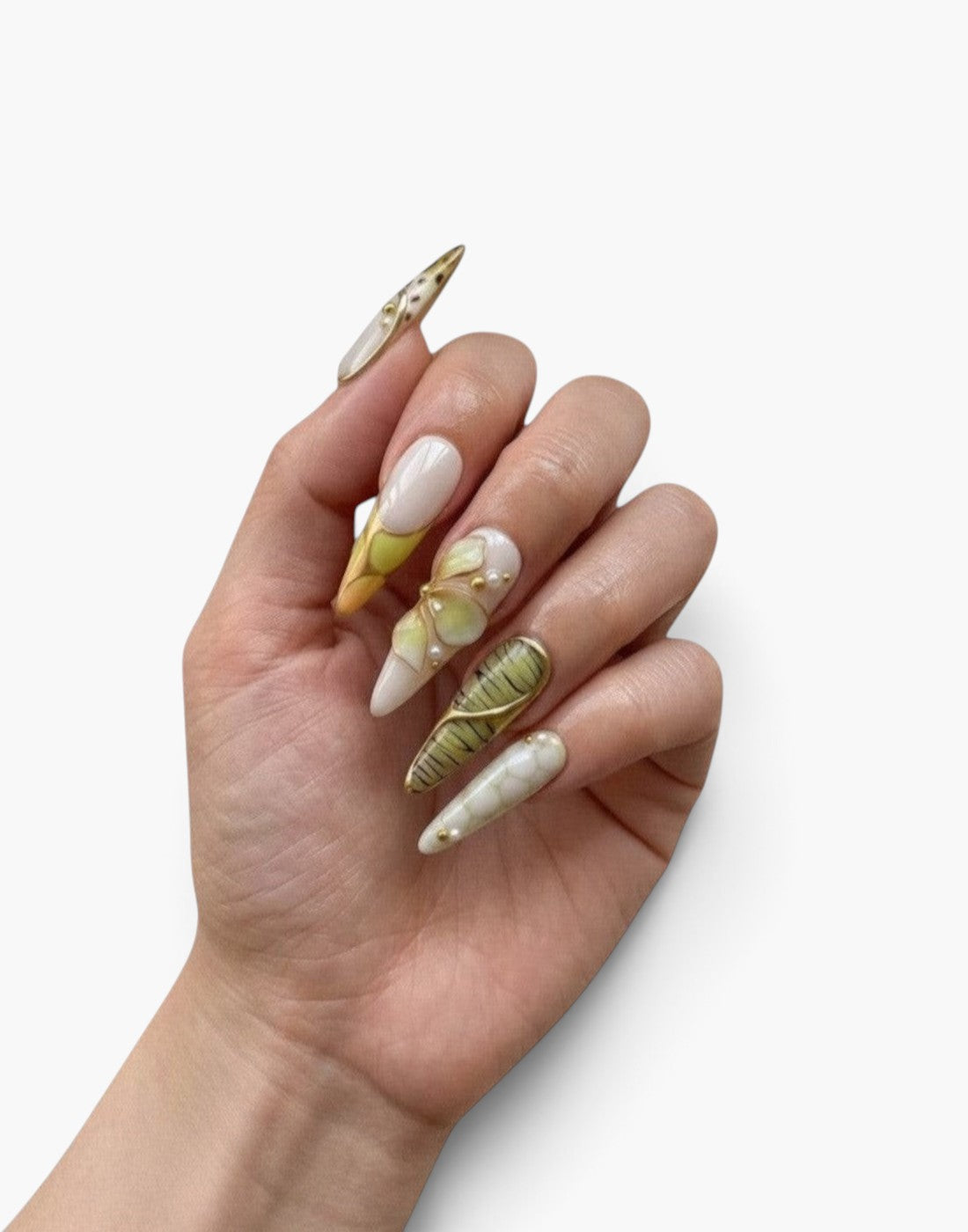 Main Cherry Rouge portant des faux ongles stiletto nude et vert menthe avec fleurs 3D, motifs animaliers et détails dorés