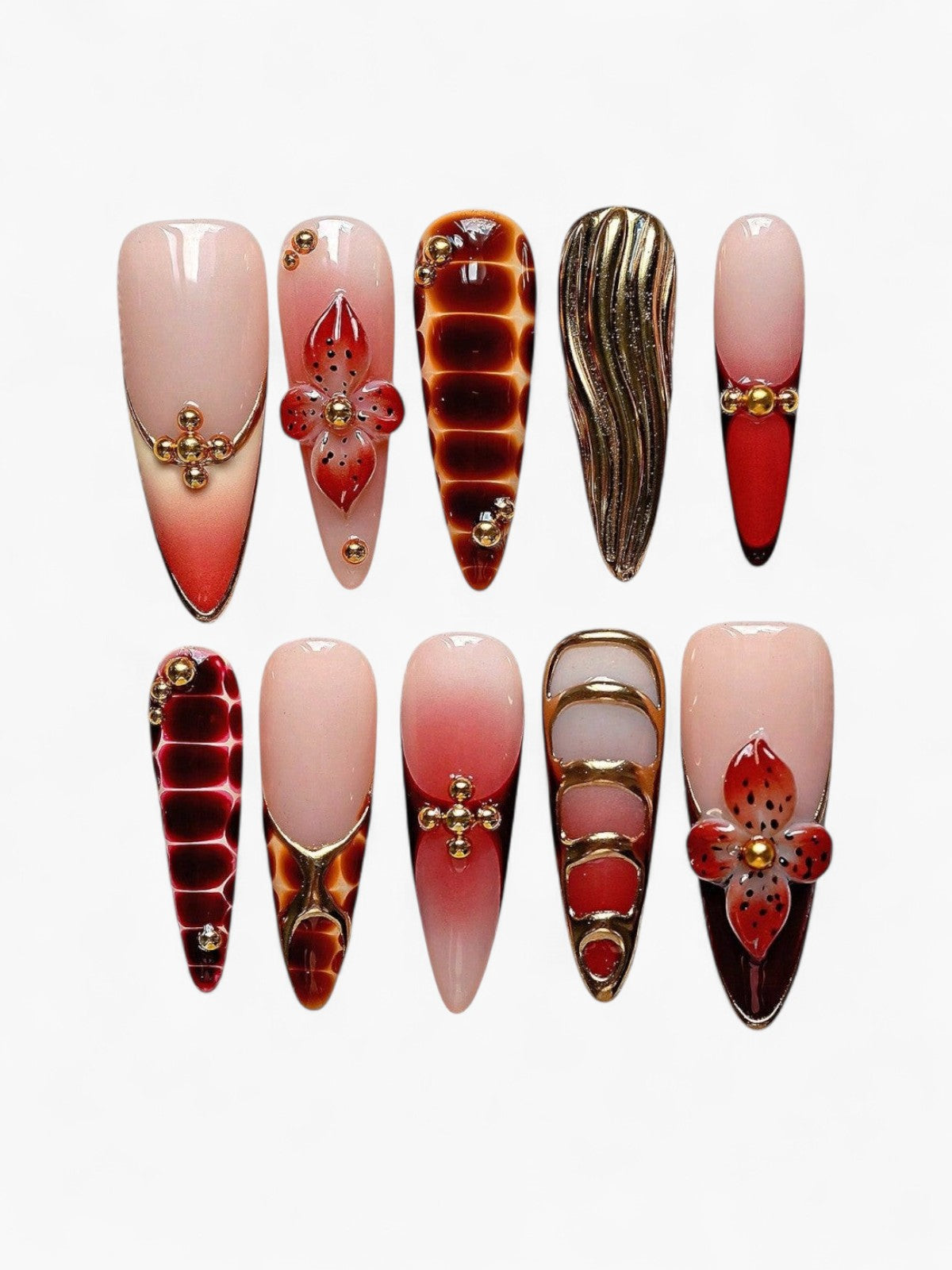 Set de 10 faux ongles Cherry Rouge Amber Reverie forme stiletto, tons ambre et caramel avec détails dorés en relief.