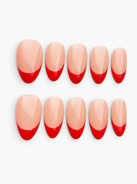 Capsules Cherry Rouge Kiss Me First en forme amande courte avec French manucure rouge moderne sur base nude brillante