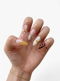 Manucure Cherry Rouge Savage Elegance avec capsules amande nude et noir, motifs géométriques et détails dorés en relief