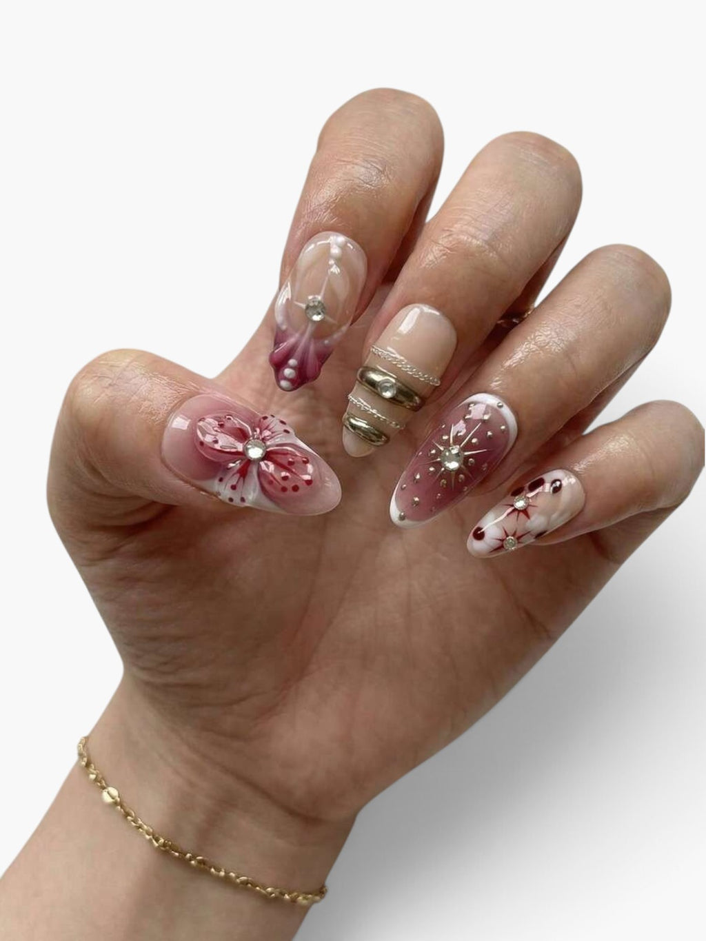 Manucure Cherry Rouge Scarlet Stardust en forme amande avec motifs floraux en relief, strass et détails en gel rouge