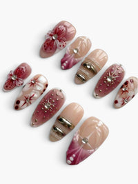 Manucure Cherry Rouge Scarlet Stardust en forme amande avec motifs fruitiers en relief et détails strass sur gel rouge