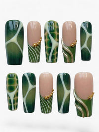 Manucure Cherry Rouge Emerald Vortex forme amande avec swirls vert émeraude, gris perle et détails dorés en gel brillant