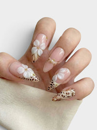 Manucure Cherry Rouge Savage Romance Leo forme amande avec fleurs 3D blanches, motifs léopard et détails dorés