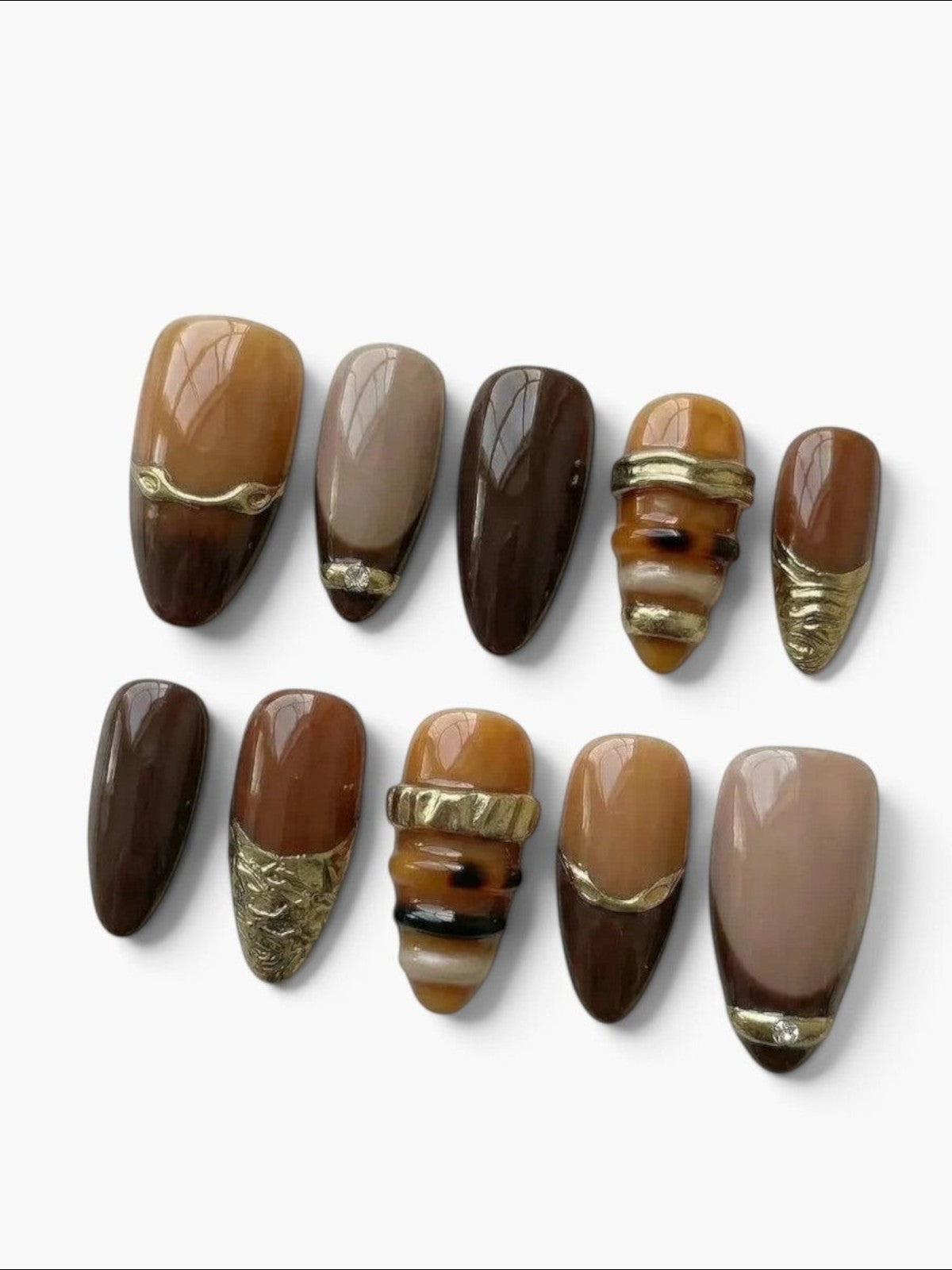 Manucure Cherry Rouge Azure Reverie en gel forme amande, dégradé marron doré brillant avec détails métalliques dorés.