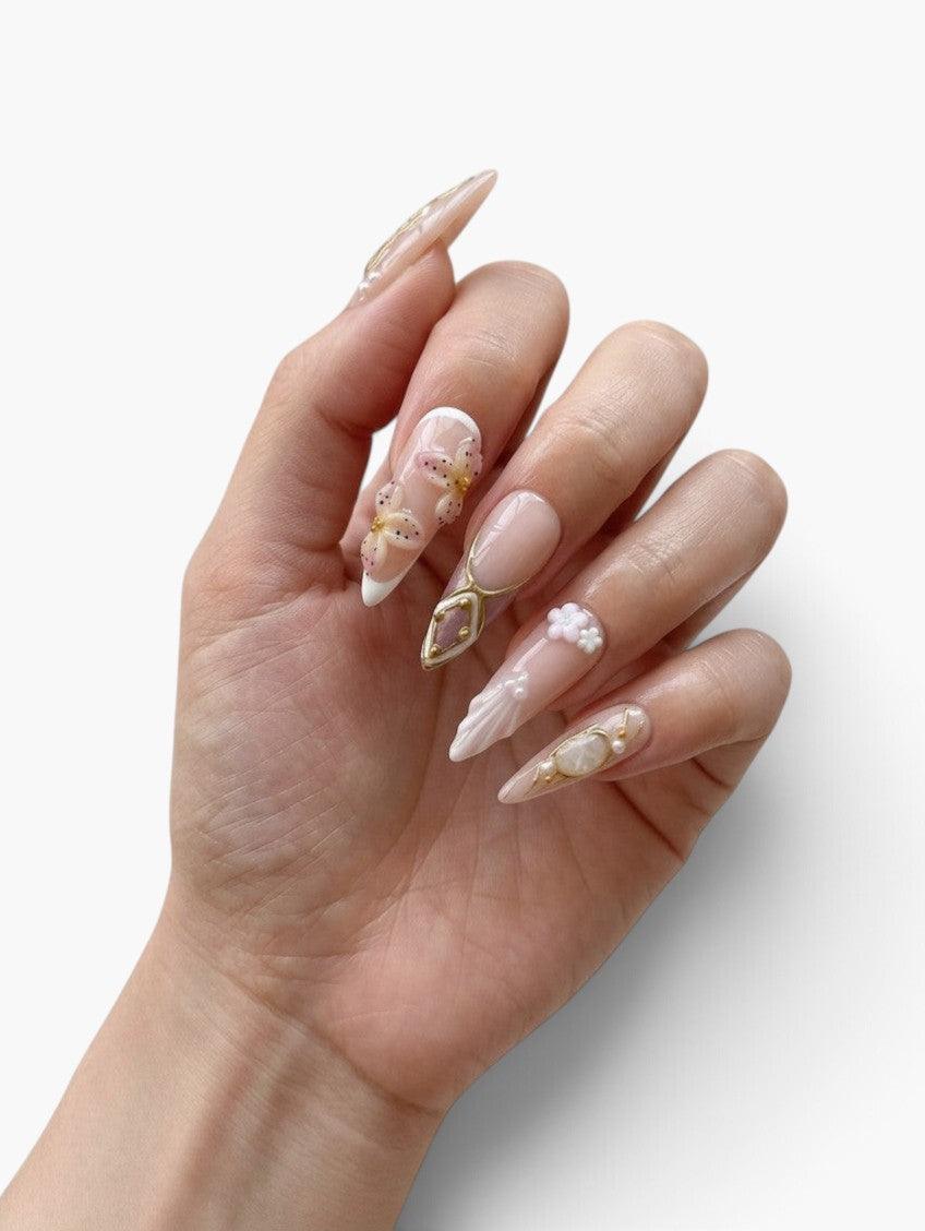 Manucure Cherry Rouge Dream Girl stiletto nude rosé et parme avec fleurs 3D, ornements dorés et effet pierre précieuse