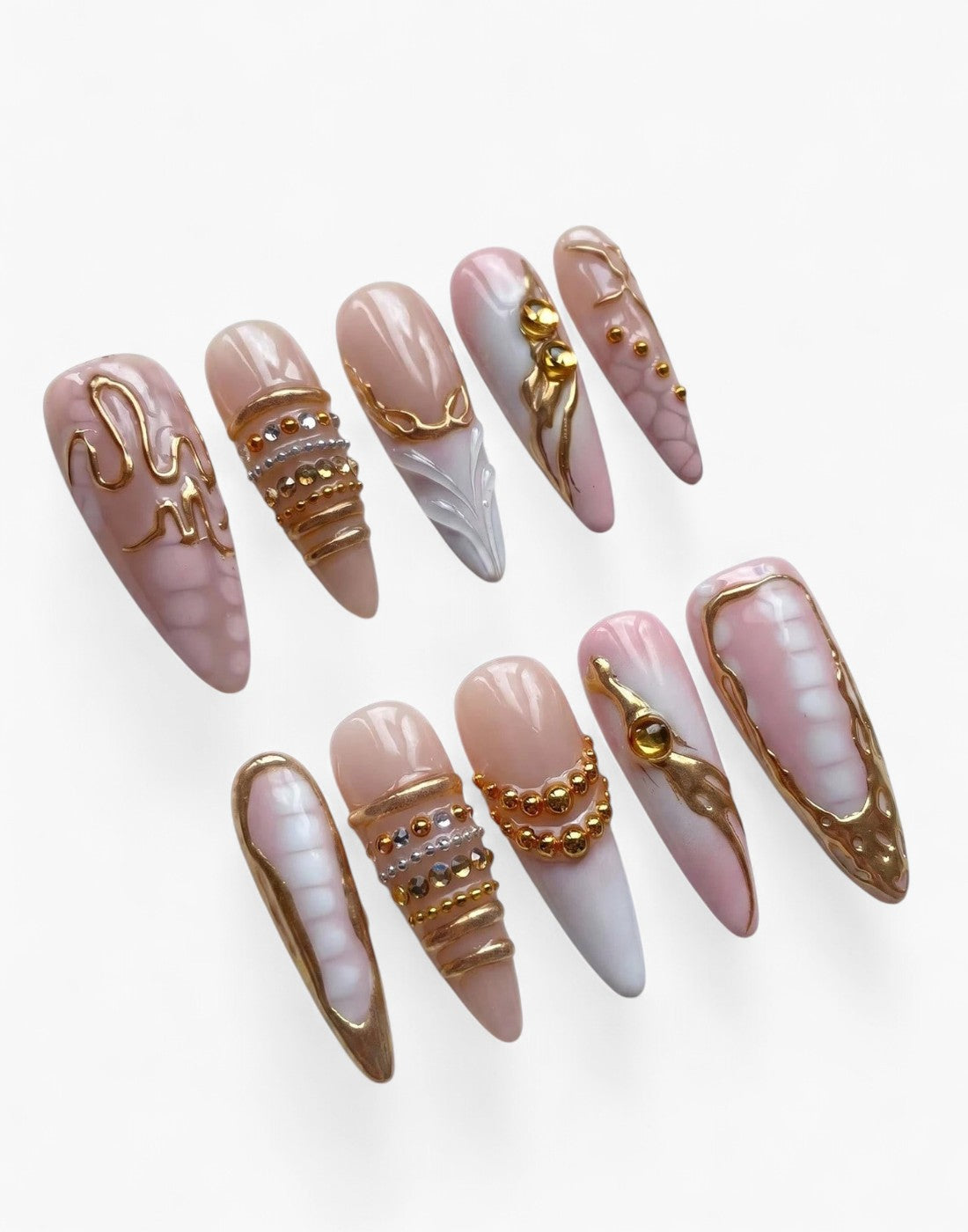 Press-on nails Cherry Rouge Liquid Grace en forme amande, tons nude et rose pâle avec détails dorés et reliefs gel.