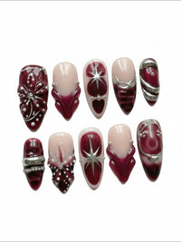 Ensemble d'ongles press-on Cherry Rouge Dewdrop Romance avec motifs bordeaux, argentés, étoiles et détails en relief.