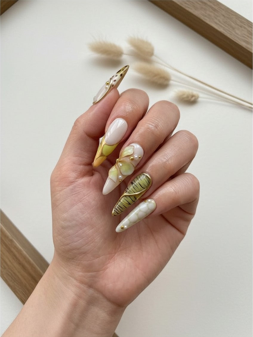 Ongles press-on Cherry Rouge longs en amande, style Y2K vert avec motifs silhouettes de plantes et détails dorés.