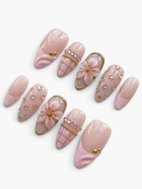 Set de 10 faux ongles Cherry Rouge Rosé Radiance en forme amande, nude rosé avec fleurs en relief et strass brillants.