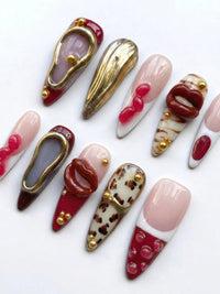 Cherry Rouge Rouge Reverie, capsules amande en gel avec dégradés bordeaux, motifs lèvres, léopard et détails dorés.