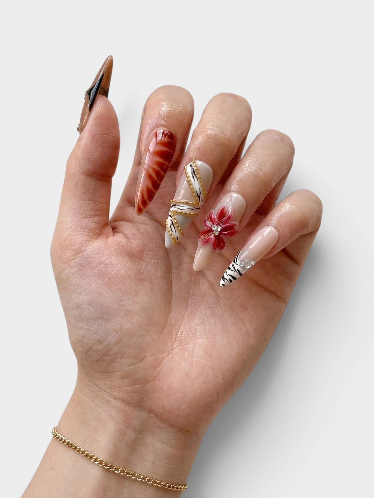 Manucure Cherry Rouge Wild Bloom Charm en forme amande avec motifs floraux 3D, détails dorés et finitions nacrées